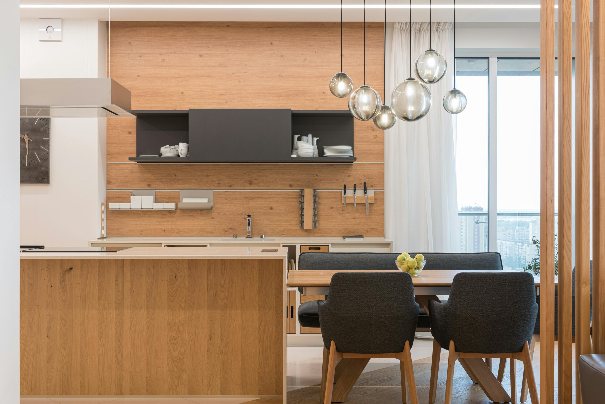 affordable interior designers in Hyderabad A modern kitchen dining area featuring wooden elements and pendant lighting, providing a warm and inviting atmosphere.