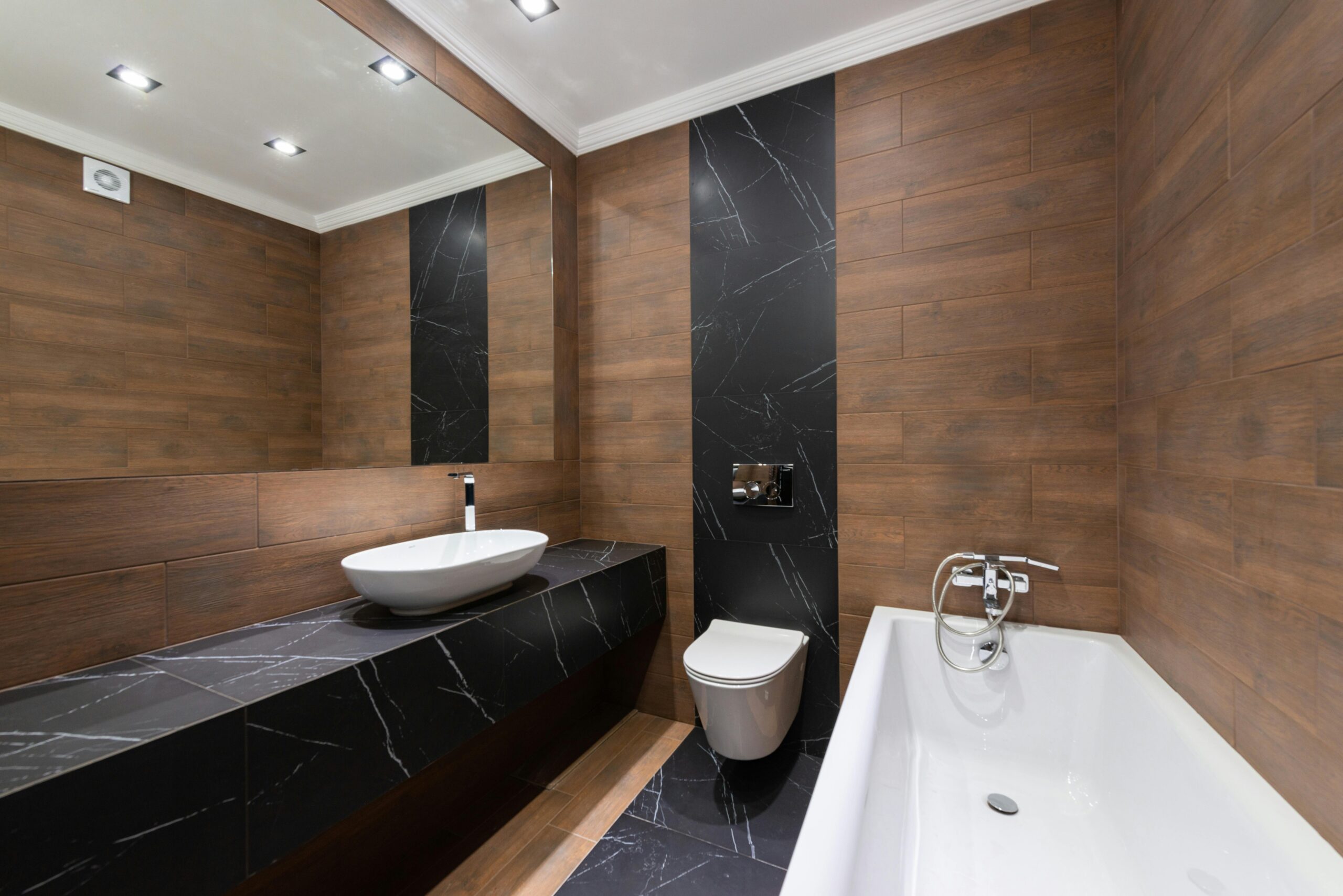 Luxury Interior designers in Hyderabad Modern bathroom with wooden accents, sleek fixtures, and minimalist design.
